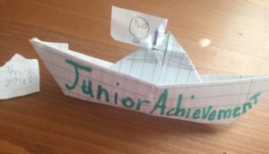 Paper boat that says Junior Achievement