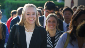 Teen girl smiling while walking in a crowd
