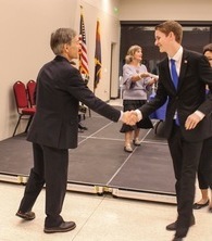 Joe Ross shaking hands with man while wearing suit
