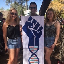 AJ Aguilar and two teen girls holding sign