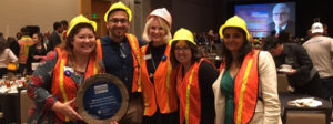 Group of 5 JA employees wearing construction uniforms and holding award for Best Place to Work