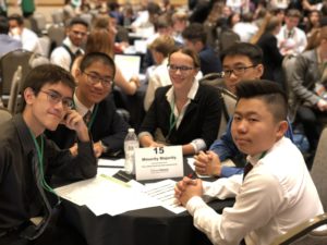 Group of students sitting around a table at student stock market challenge