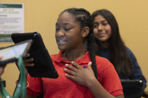African American female students smiling at iPad